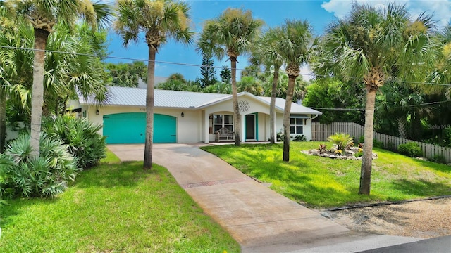 view of front of house with a garage, driveway, a front yard, and stucco siding