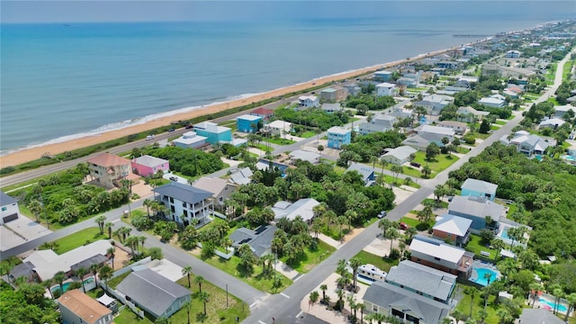 birds eye view of property with a water view and a beach view