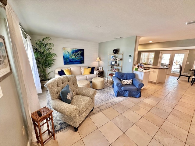 living room with light tile patterned flooring, french doors, and a textured ceiling