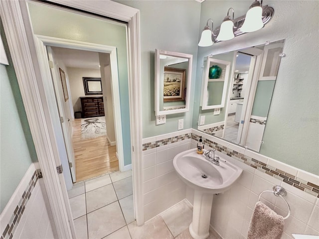 bathroom featuring sink, tile walls, wood-type flooring, and decorative backsplash