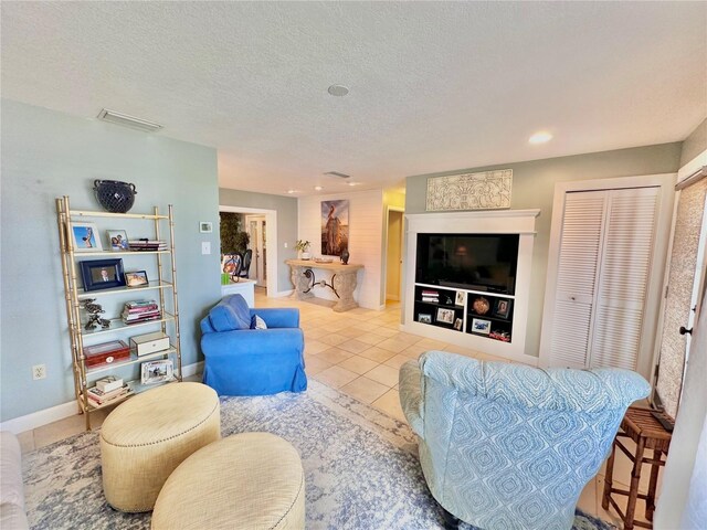 living room with a textured ceiling and light tile patterned floors