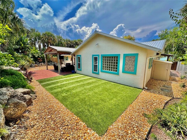 back of property with a lawn and a patio area