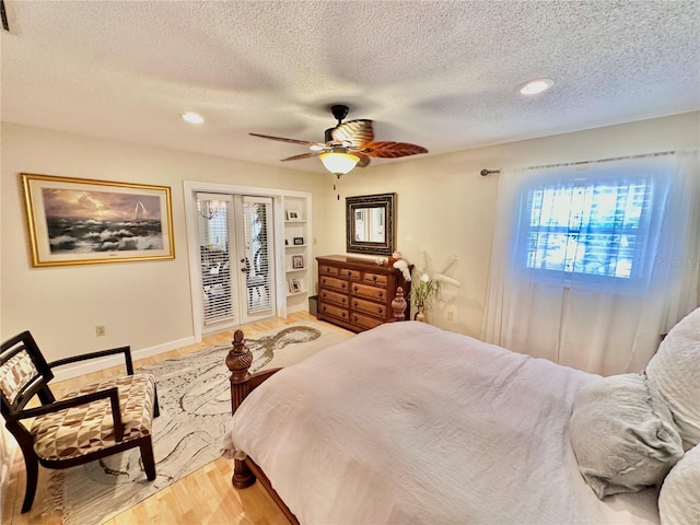 bedroom featuring ceiling fan, access to exterior, hardwood / wood-style flooring, and a textured ceiling