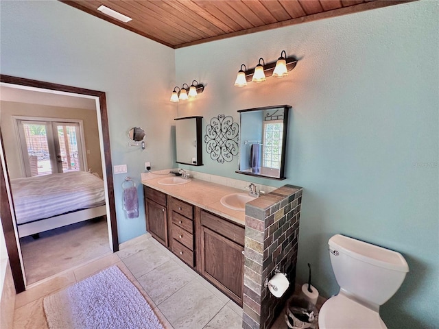 bathroom featuring wooden ceiling, double sink vanity, toilet, and tile patterned flooring