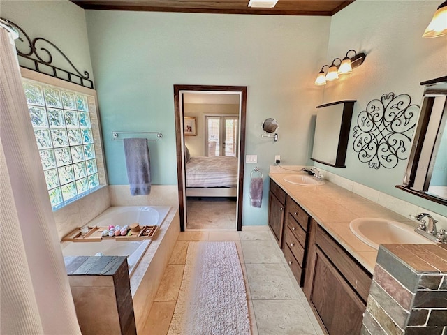 bathroom featuring dual vanity, a relaxing tiled tub, and tile patterned flooring