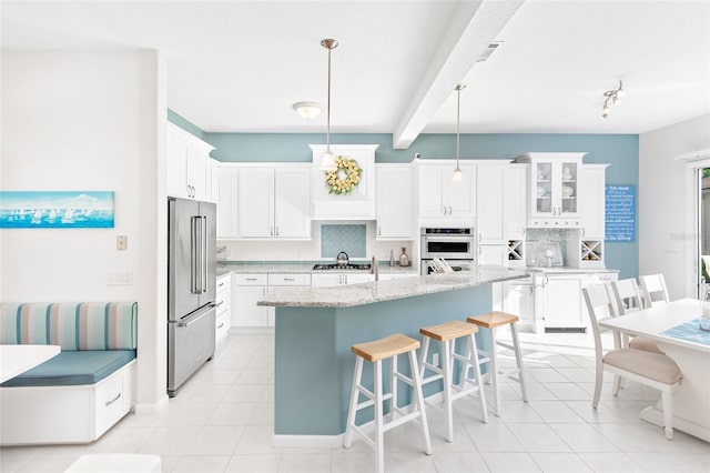 kitchen featuring white cabinets, backsplash, appliances with stainless steel finishes, and pendant lighting