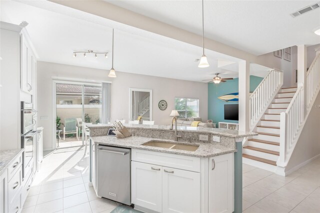 kitchen with light tile patterned flooring, dishwasher, sink, and ceiling fan