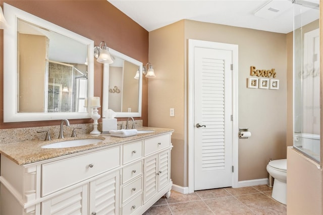 bathroom featuring tile patterned floors, toilet, and double sink vanity