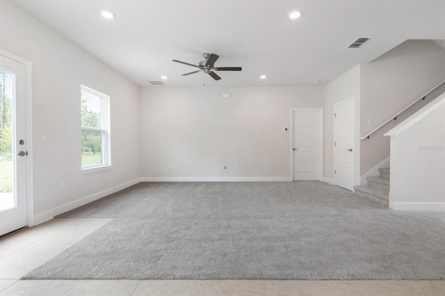 unfurnished room with light colored carpet and ceiling fan