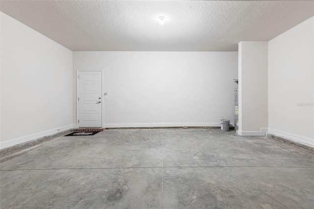 garage with baseboards and secured water heater