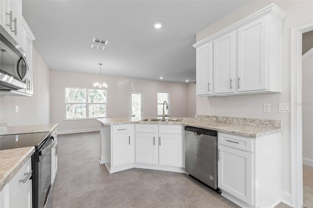 kitchen with visible vents, a sink, stainless steel appliances, a peninsula, and white cabinets