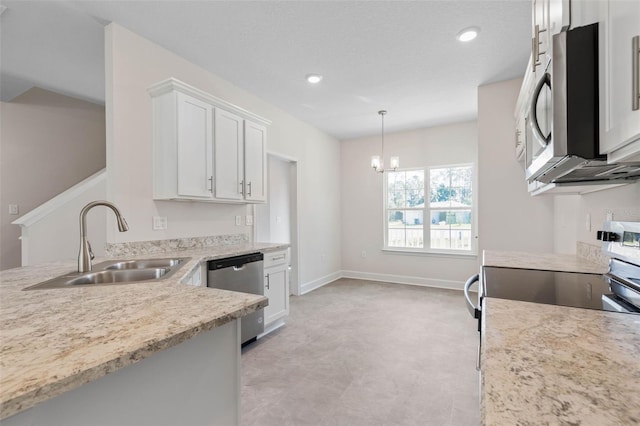 kitchen featuring baseboards, a sink, appliances with stainless steel finishes, white cabinetry, and a notable chandelier