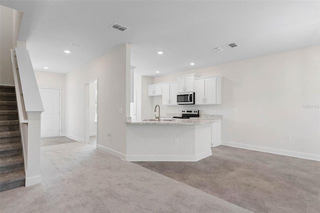 kitchen featuring baseboards, visible vents, a sink, appliances with stainless steel finishes, and white cabinetry