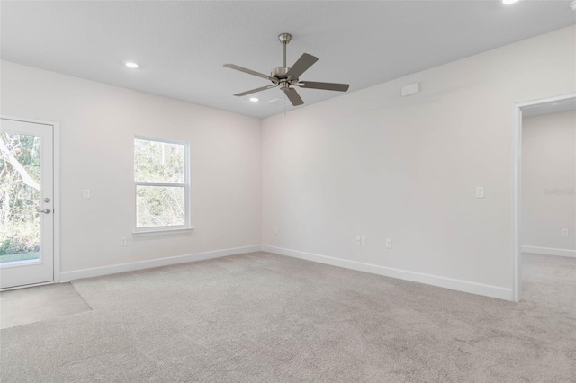 carpeted spare room featuring recessed lighting, a ceiling fan, and baseboards