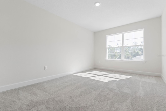 carpeted spare room with baseboards