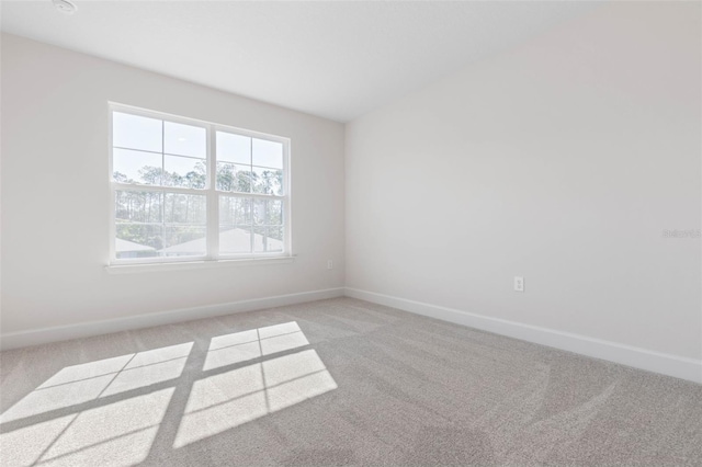 empty room featuring baseboards and carpet flooring