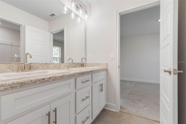 full bathroom featuring double vanity, baseboards, visible vents, and a sink