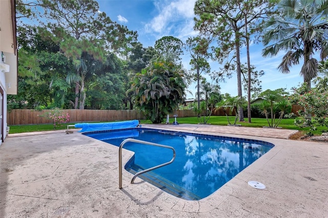 view of pool featuring a lawn and a patio