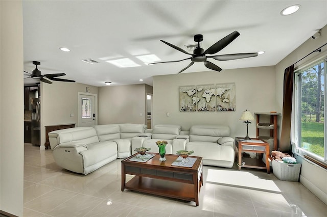 living room featuring ceiling fan, light tile patterned floors, and a wealth of natural light