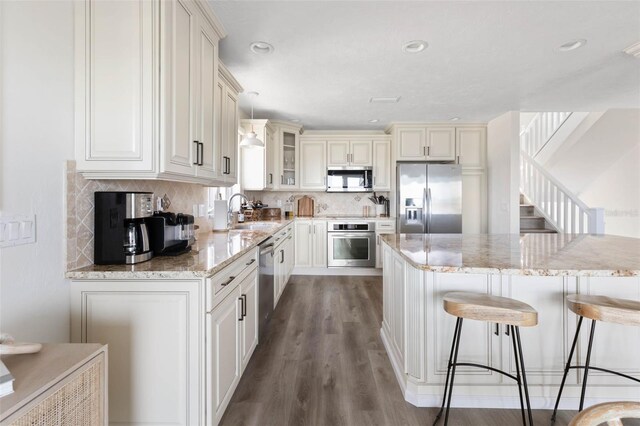 kitchen featuring a center island, hardwood / wood-style floors, stainless steel appliances, sink, and pendant lighting