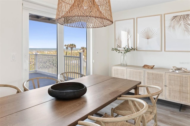 dining area featuring a water view and hardwood / wood-style flooring