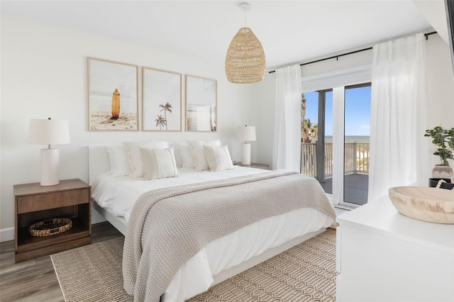 bedroom featuring access to exterior and light wood-type flooring