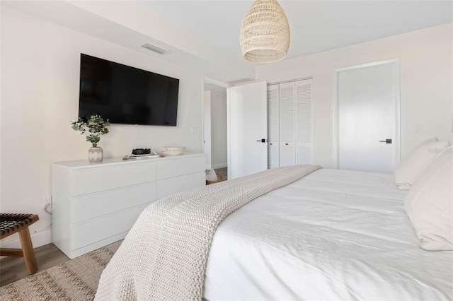 bedroom with a closet, visible vents, and light wood-style flooring