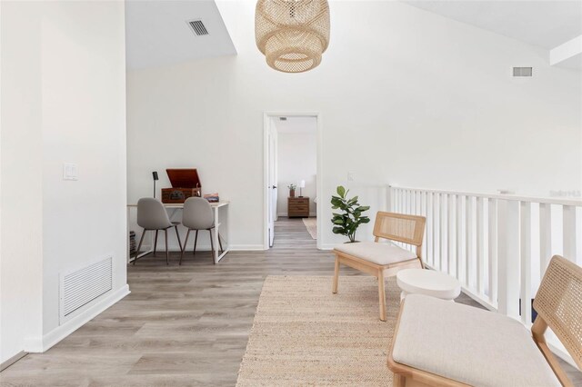 living area with high vaulted ceiling and light wood-type flooring