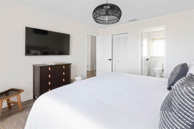 bedroom with a closet, wood-type flooring, and ensuite bathroom