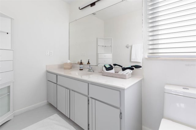 bathroom featuring toilet, vanity, and baseboards