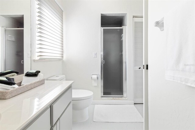 bathroom featuring vanity, toilet, an enclosed shower, and tile patterned flooring