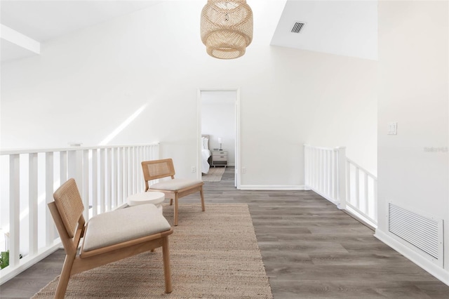 living area with dark wood-style flooring, a towering ceiling, visible vents, and baseboards