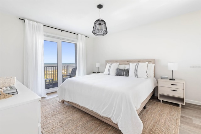 bedroom with baseboards, light wood-style floors, and access to exterior