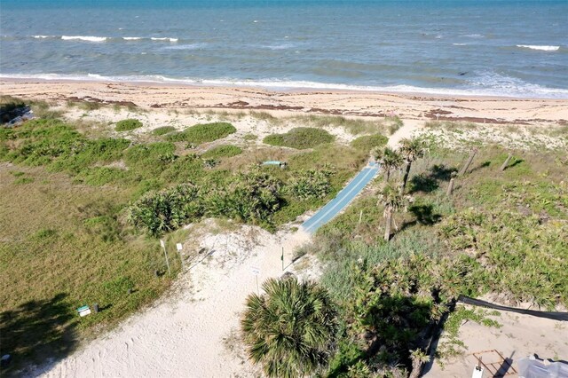 birds eye view of property featuring a water view and a beach view