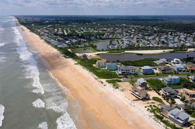 aerial view featuring a view of the beach, a water view, and a residential view