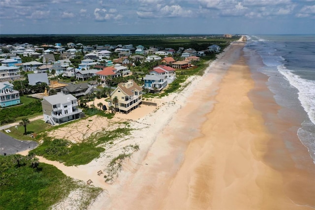 aerial view featuring a view of the beach, a water view, and a residential view