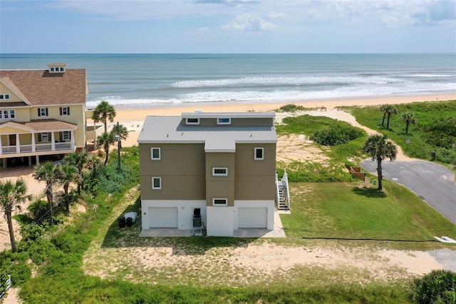 drone / aerial view featuring a beach view and a water view