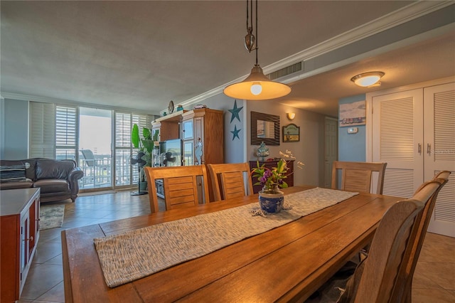 tiled dining space featuring ornamental molding