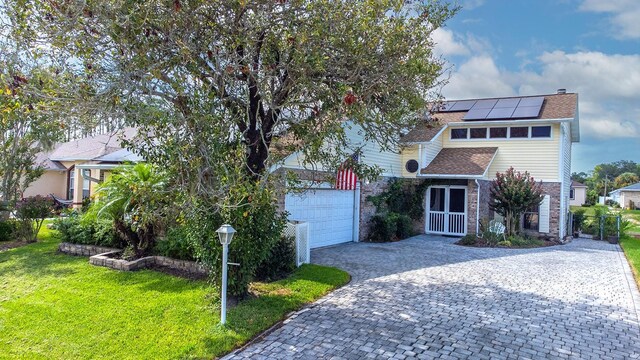 view of front of home featuring a front yard and solar panels