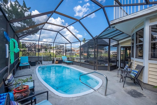 pool featuring glass enclosure and a patio area