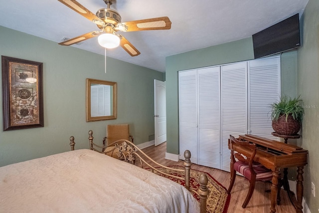 bedroom with ceiling fan, a closet, and wood finished floors