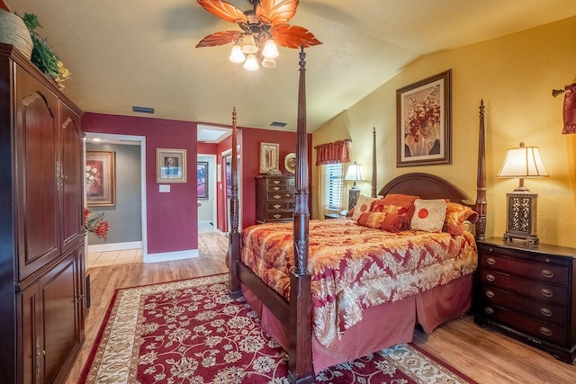 bedroom featuring lofted ceiling, a ceiling fan, visible vents, and light wood-style floors