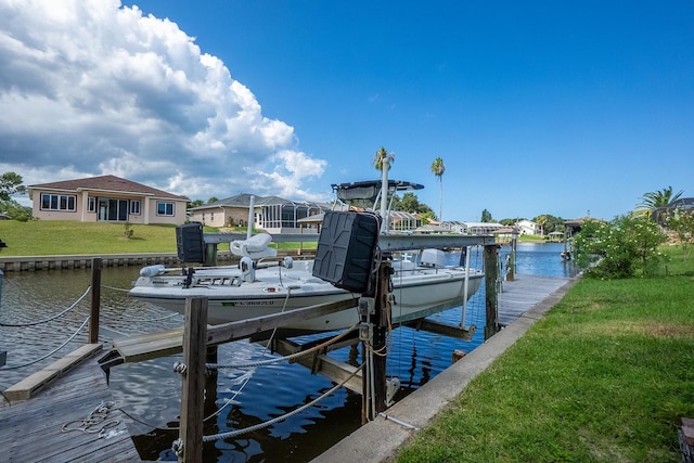 view of dock featuring a water view, a yard, and boat lift