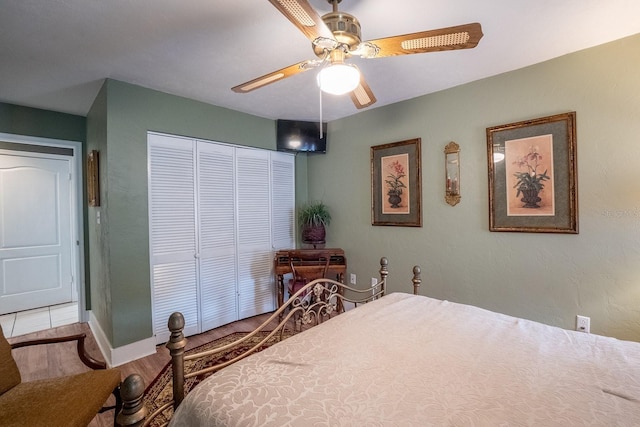 bedroom featuring a closet, light wood-style flooring, and a ceiling fan