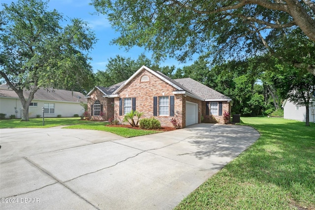 ranch-style house with a garage, a front lawn, and central air condition unit