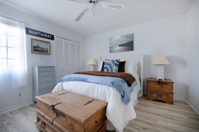 bedroom with ceiling fan, light wood-type flooring, and a closet