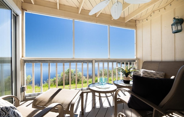 sunroom / solarium with beam ceiling, a water view, ceiling fan, and wooden ceiling