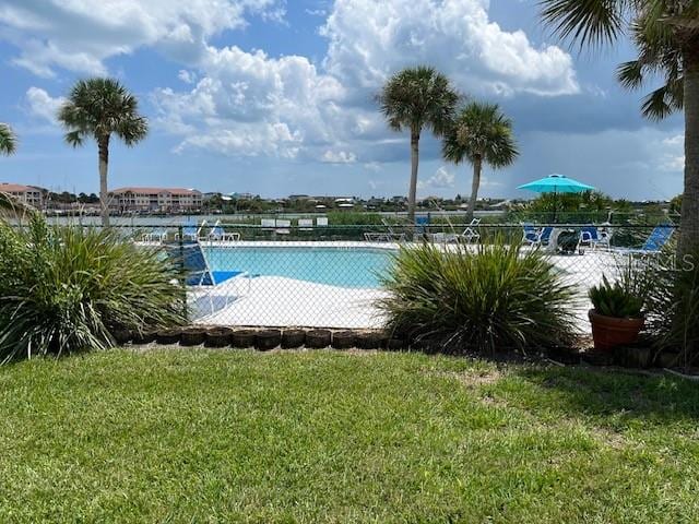 view of pool featuring a lawn