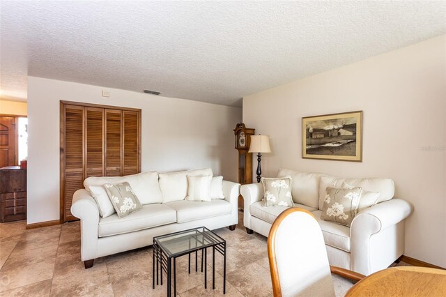 living room featuring a textured ceiling and light tile patterned flooring