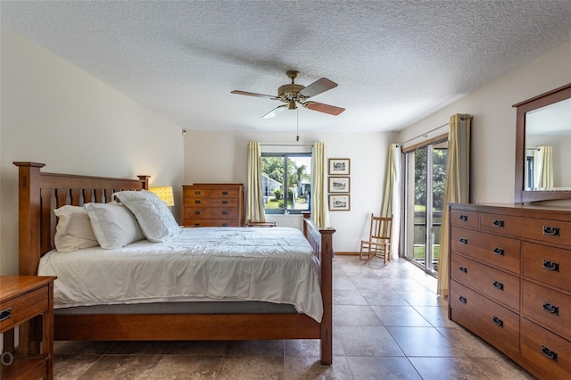 bedroom featuring access to exterior, multiple windows, a ceiling fan, and a textured ceiling